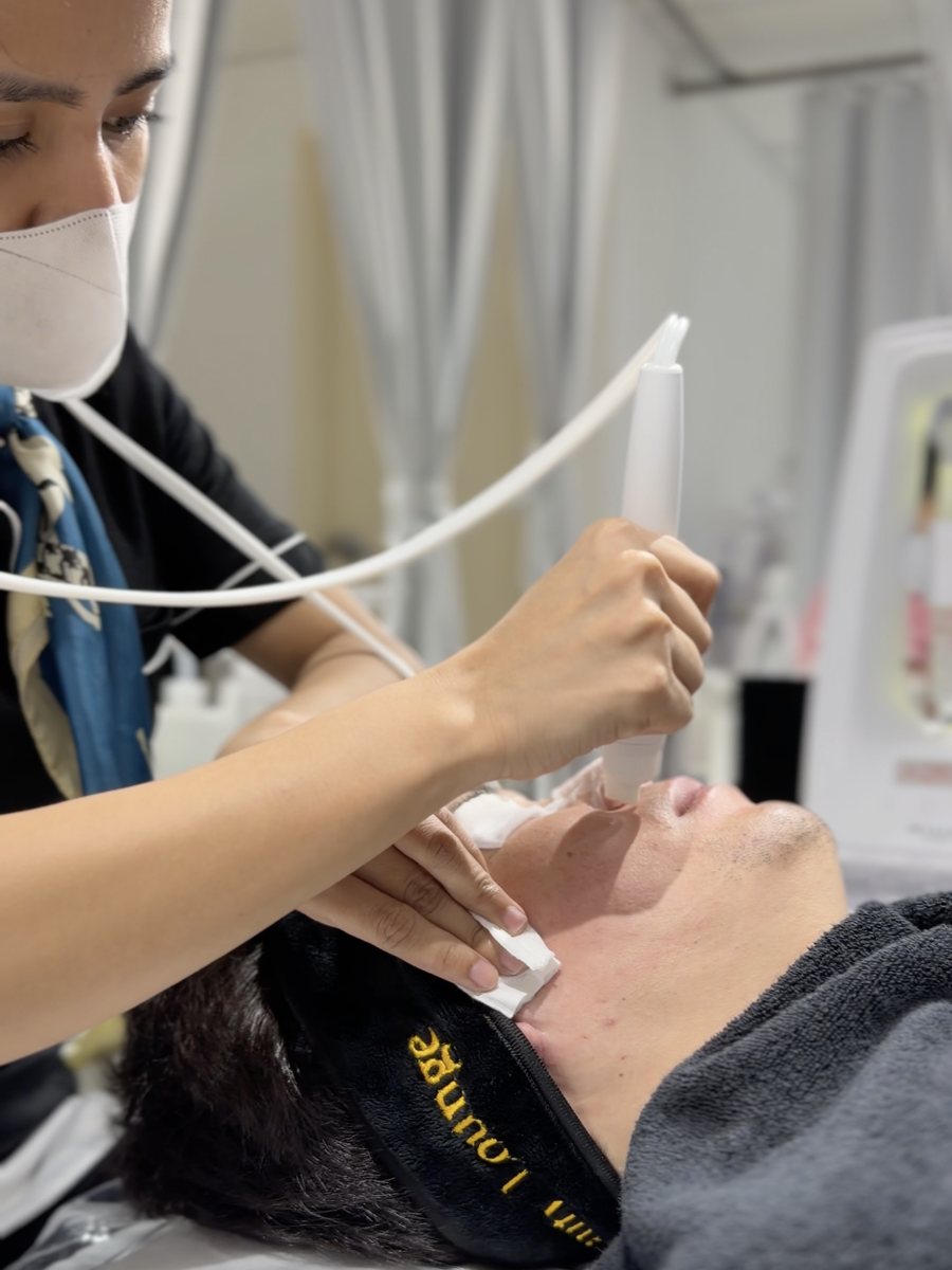 A therapist performing a HydraFacial treatment